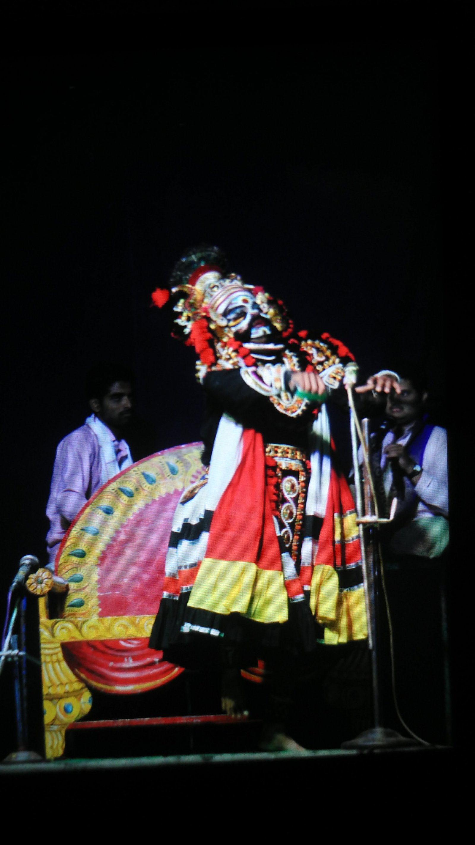 Yakshagana performers on stage in elaborate costume and traditional make-up